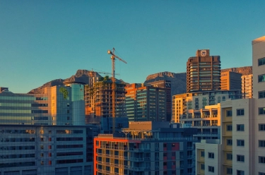 Panorámica de una metrópoli con el cielo despejado y una grúa de construcción en el fondo